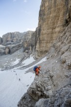 Mountaineer climbs on an exposed rock in the secured Via Ferrata Bocciere Centrale via ferrata,