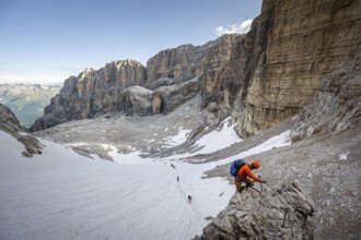 Mountaineer climbs on an exposed rock in the secured Via Ferrata Bocciere Centrale via ferrata,