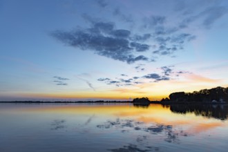 Sunset over quiet Dümmer See with colorful sky and clouds reflecting in the water, Lembruch, Dümmer