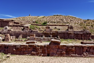 Ancient stone ruins under a clear blue sky surrounded by dry, grassy landscape, The archaeological