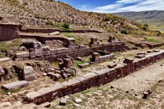 Ancient ruins and stones on a hill with a wide view under a blue sky, the archaeological site with
