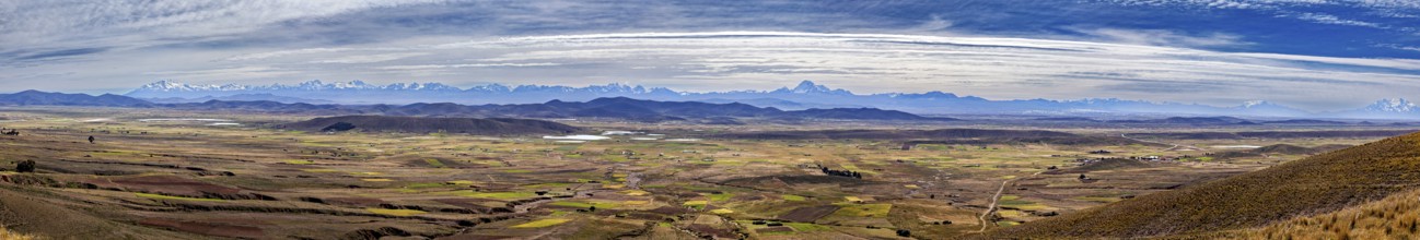 Extensive panorama with mountains and fields under cloudy sky, The Altiplano landscape in the Andes
