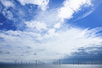 Wide landscape with offshore wind turbines from the Kriegers Flak 2 offshore wind farm under a blue