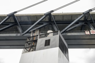 Bottom view of a metal Øresund bridge structure and a ship chimney, bridge at dusk with bright sky