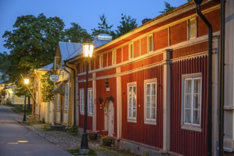 Street scene in the old town of Naantali, red historic wooden building with decorative windows on a
