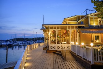 Historic harbour bridge with a warmly lit Merisali restaurant at the marina marina, Naanatali,