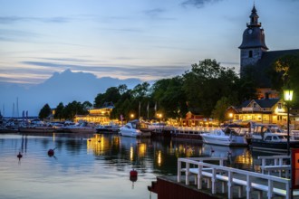 Street scene in the old town of Naantali, evening mood at the harbor with illuminated buildings and