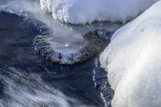 Ilsenburg, Saxony-Anhalt, Germany, detailed view of ice and snow on a flowing body of water on the