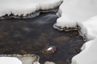 Ilsenburg, Saxony-Anhalt, Germany, Small frozen river Ilse in the Harz National Park on the