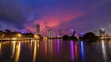 City landscape at night with impressive lights and colorful sky above the water surface, the