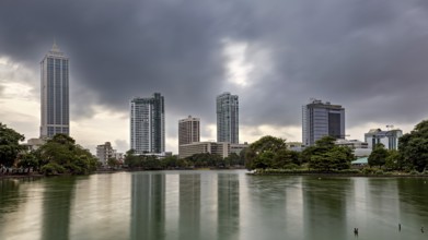 Cityscape with skyscrapers and a lake under a cloudy sky, the skyline of Colombo Sri Lanka at night