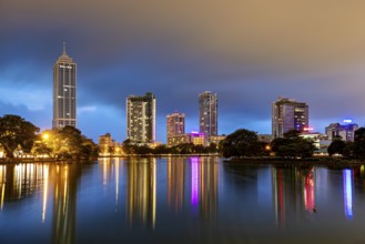 Nighttime cityscape with illuminated skyscrapers and reflections in the lake, the skyline of