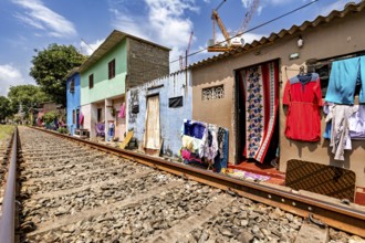 Colourful houses along railroad tracks with clothes hung up in an urban setting, railway line in