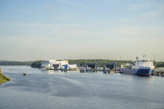 Large ferries and ships are moored at the port of Scandinavia Quay in Travemünde with deep blue