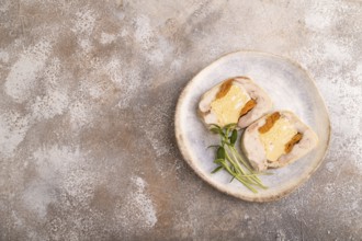 Chicken, egg and dried apricot meatloaf, microgreen on brown concrete background. top view, flat