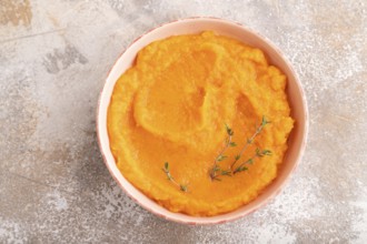 Sweet potato porridge in ceramic bowl on brown concrete background. Diet, healthy eating concept.