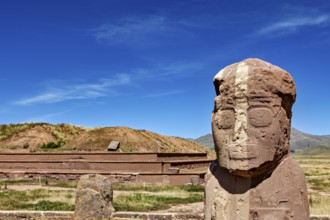 Stone statue in front of a ruined landscape under clear blue sky, The archaeological site with the