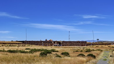 Stone ruins surrounded by pristine meadow and clear skies, evoke a sense of vastness, The