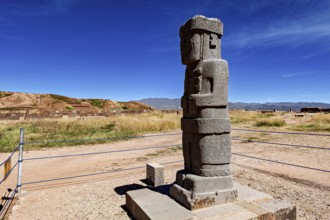 Stone monument with engravings in a wide landscape under blue sky, The archaeological site with the