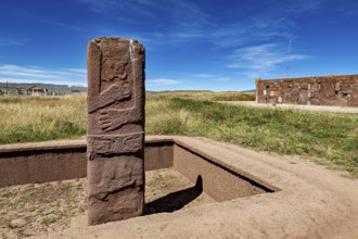 Upright ancient stone column in scenic surroundings under blue sky, The archaeological site with