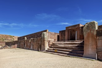 Broad view of ruins with stone entrances and stairs under clear skies, The archaeological site with