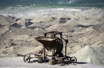 Old rusted moving mill for rock in front of mountain landscape with Kennicott Glacier, Historic