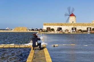Cyclist photographs salt museum, traditional windmill, saltworks di Trapani and Paceco nature