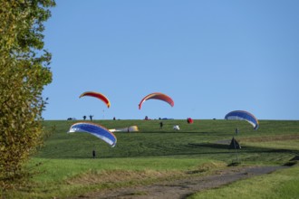 Paragliders practice on a meadow slope, Tauchersreuth, Middle Franconia, Bavaria, Germany