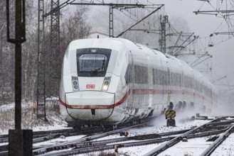ICE traveling through a winter landscape in snowfall. A train on the line in the Deutsche Bahn