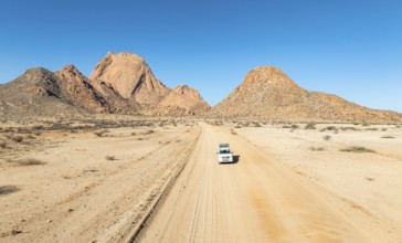Aerial view, car on sandy road, mountains in the desert, Spitzkoppe summit, Namib desert, Namibia