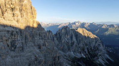 Aerial view, alpine panorama, rocky peaks at sunrise with alpine glow, picturesque mountain