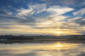 Sunrise with fog on a lake at the Ahlhoner fish ponds, Ahlhorn, Lower Saxony, Germany