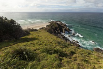 Sunlit daytime view with lookout platform below and glowing cliffs at Cape Byron, New South Wales,