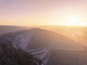 Natural hill in the soft light of a bright winter morning, old deposit, construction site for PV