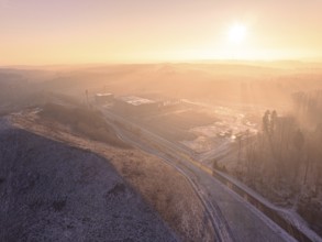 Hill against morning light, surrounded by gentle fog landscape, old deposit, construction site for