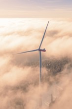 Wind turbine in the middle of a foggy landscape while the sun is behind clouds, Bad Wildbad, Calw
