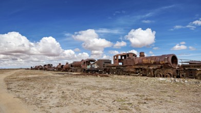 Row of abandoned, rusty locomotives in a desert-like environment, old rusty locomotives at the