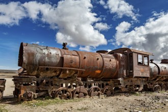 Rusty locomotive in a vast, cloudy and open landscape, old rusty locomotives at the train cemetery