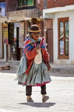 Elderly woman in colorful, traditional clothing with colorful scarf on a city street in Bolivia,