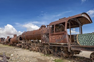 Close-up of a rusted locomotive with graffiti under a cloudy sky, old rusty locomotives at the