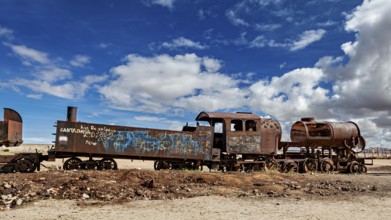 Weathered locomotive in the desert with clouds in the blue sky, old rusty locomotives at the train
