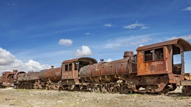 Rusty old trains on dry ground under blue skies, old rusty locomotives at the train cemetery near