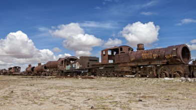 Abandoned and rusted locomotives under a clear sky with white clouds, old rusty locomotives at the