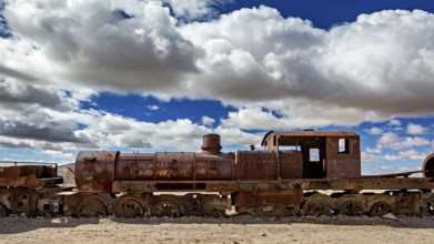 Rusty locomotive in a barren desert landscape with dramatic clouds, old rusty locomotives at the