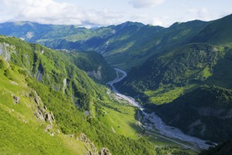 Breathtaking panorama of green mountains and a river valley surrounded by rich nature, landscape