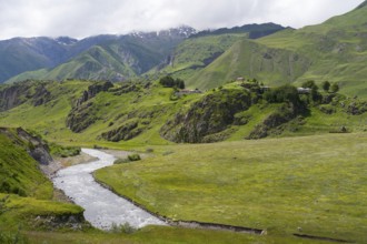 Peaceful green landscape with a river nestled in a wide valley surrounded by mountains, landscape
