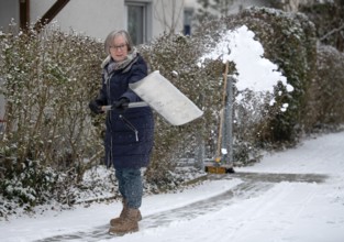 Elderly woman sweeping week with snow shovel, snow shovel, snow remover, shovel, clear, shovel