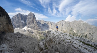 Mountaineers on a rock in front of picturesque mountain landscape with rocky peaks, Via Ferrata