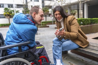 Young woman sitting on a bench, showing content on a smartphone and engaging in communication with