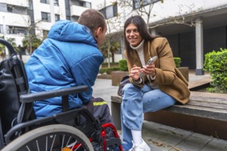 Woman and man with disability in wheelchair engaging in an inclusive outdoor conversation, sharing